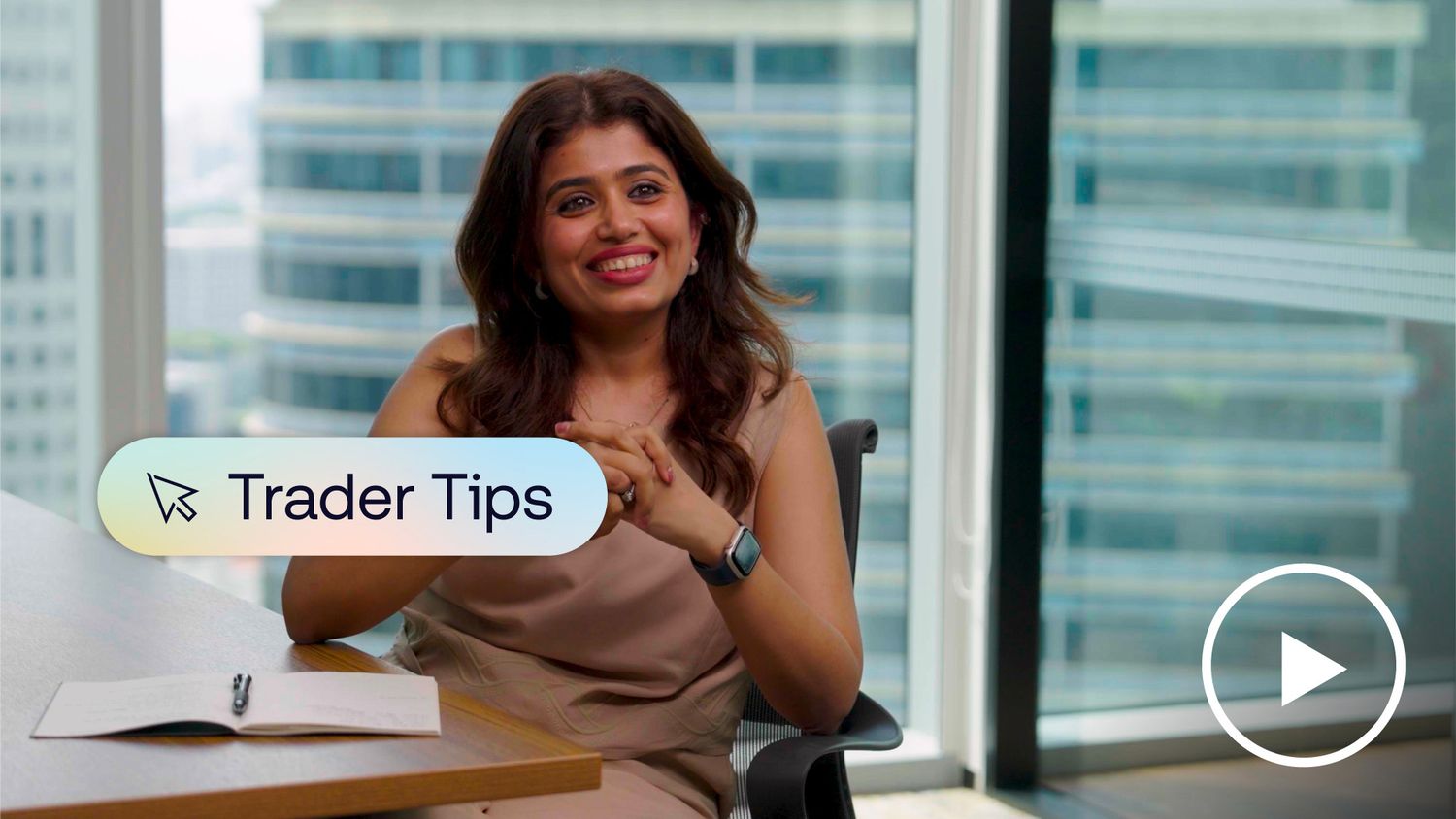 Smiling woman sitting at desk in city office.